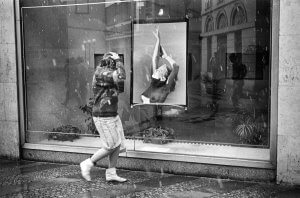 Woman and photo in a gallery window.. Prague, Czech Republic.