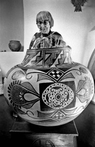 Maria Martinez. Native pueblo potter. New Mexico. Examining a traditional pot.