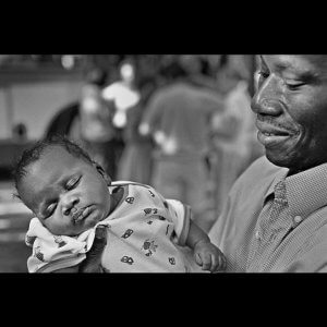 African father lovingly holding his baby daughter. Paris, France.