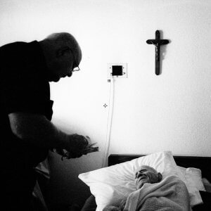 Old man getting his Last Rights from a priest