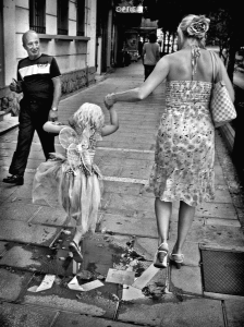 Young girl with wings jumping puddle. Girl at first communion. Marbella Spain.