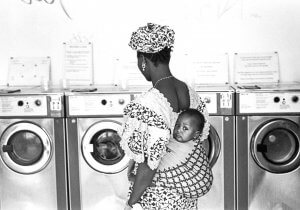 African with baby. Laundromat. Paris, France.