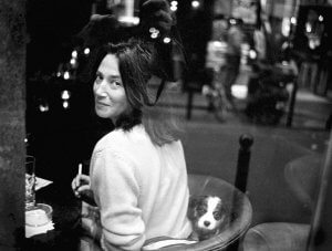 Woman with cigarette and puppy dog in a restaurant. Paris.
