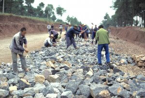 Road crew making gravel with sludge hammers.